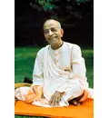 Prabhupada Smiling Sitting on Orange Blanket on Grass