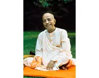 Prabhupada Smiling Sitting on Orange Blanket on Grass