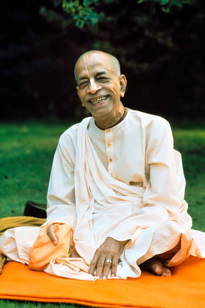 Prabhupada Smiling Sitting on Orange Blanket on Grass