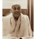 Srila Prabhupada sitting with eyes wide open and big smile